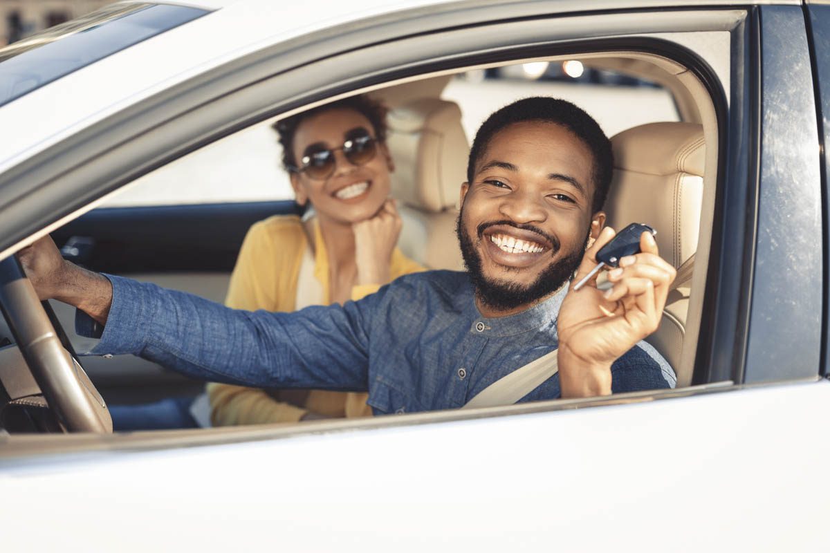 Man smiling in the car and holding a key fob | Car Insurance in Charleston, IL by Cooper Bumpus Insurance Agency